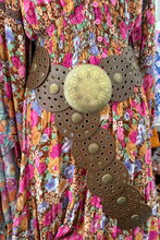 Boho belt with gold circular designs on a colorful fabric background