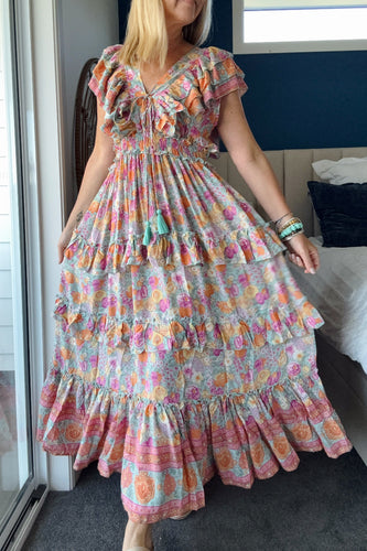 A Woman wearing a colorful boho floral dress in a bedroom setting