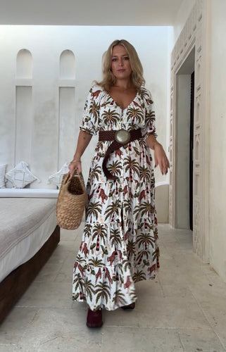 A woman wearing a short-sleeve luxe jungle print maxi dress, v-neck, in a white indoor background.